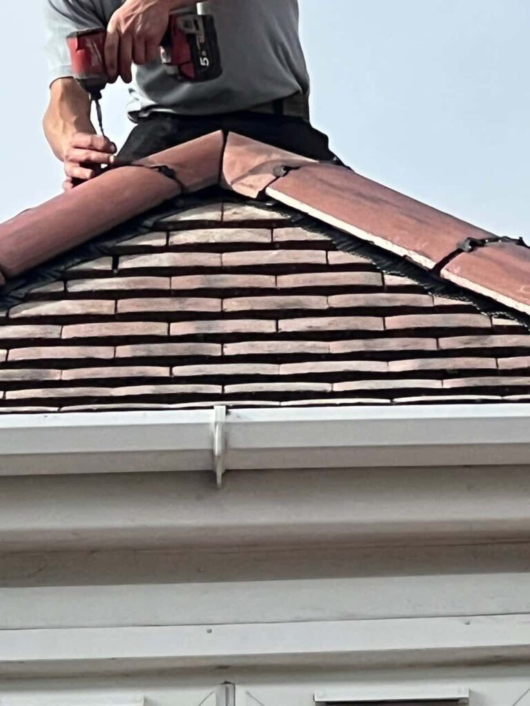 This is a photo of one of the operatives of Stapleford Roofing Repairs installing new ridge tiles