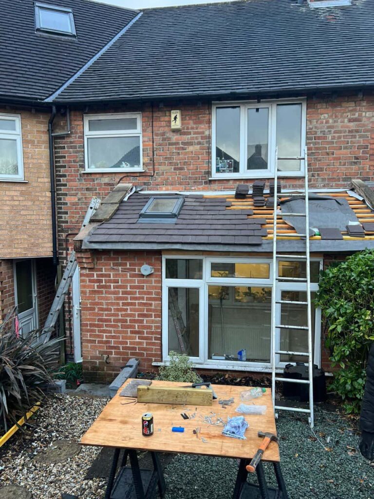 This is a photo of a roof extension that is having new roof tiles installed. This is a photo taken from the roof ridge looking down a tiled pitched roof on to a flat roof. Works carried out by Stapleford Roofing Repairs