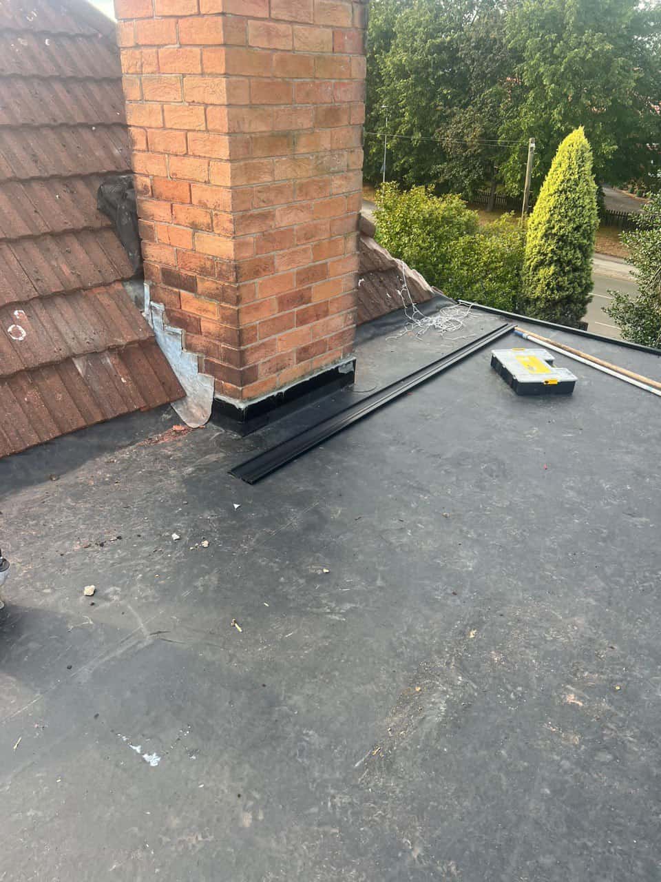 This is a photo of a flat roof which has just been repaired, there is also a chimney stack and some leadwork has also been dressed. Works carried out by Stapleford Roofing Repairs